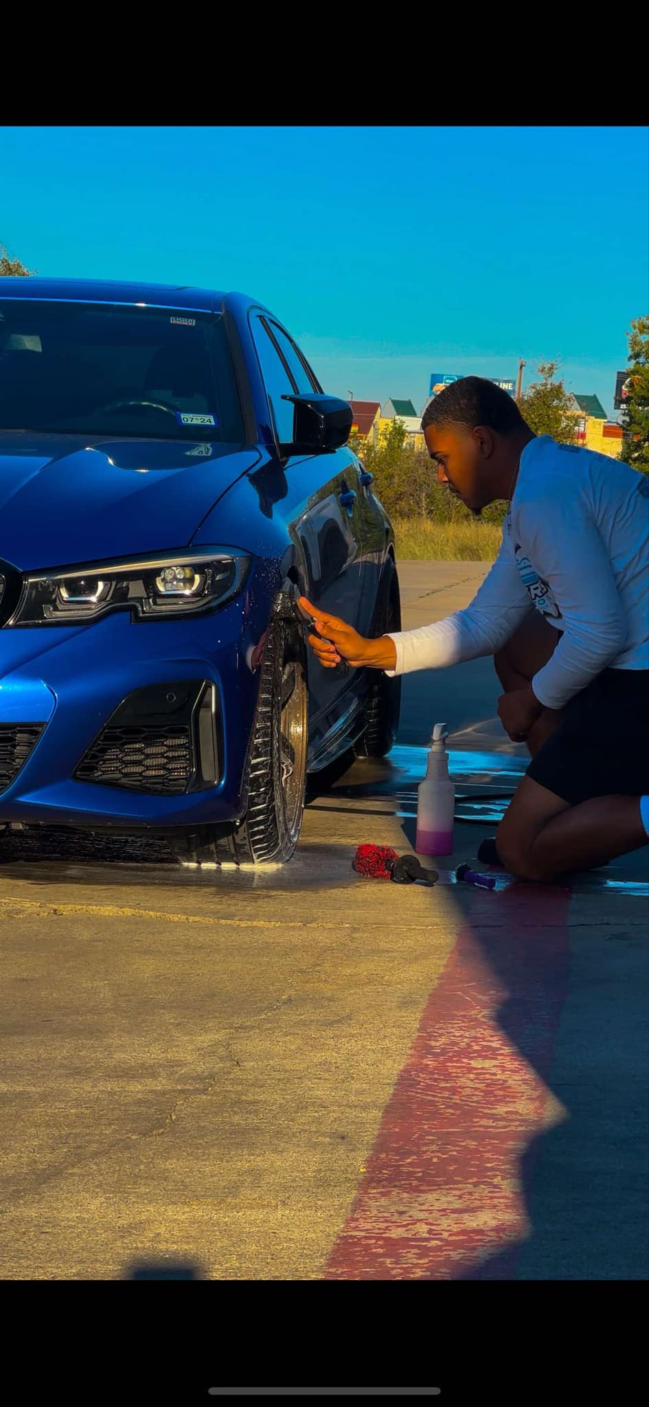 Skyrides Auto Care technician applying ceramic coating to a Tesla Model X in Killeen, TX.